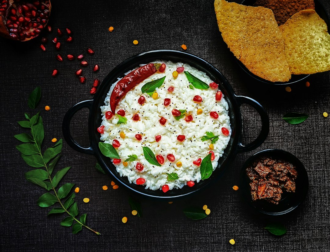 Curd-based breakfast bowl topped with pomegranate and curry leaves