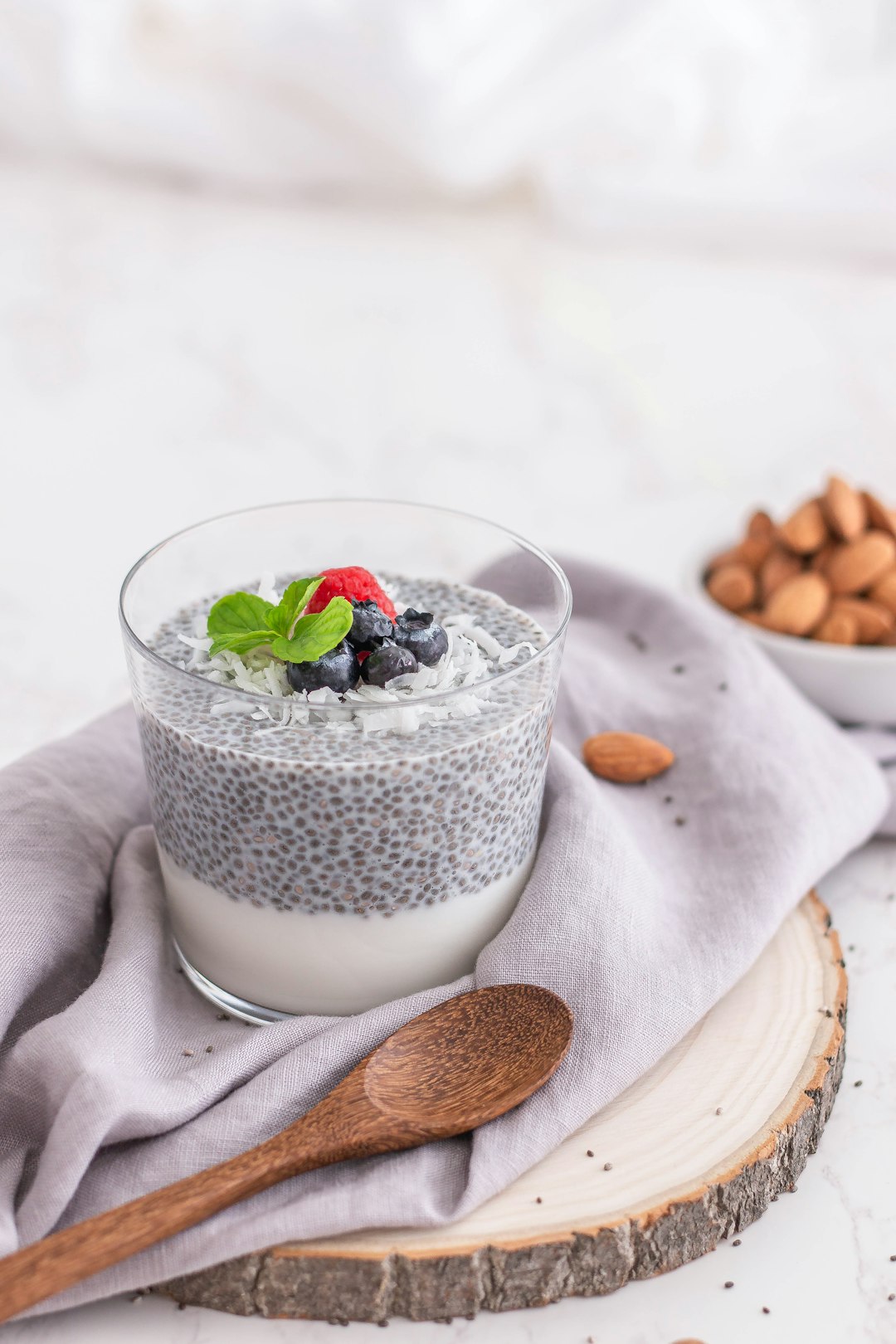 Seed pudding in a glass topped with berries and mint